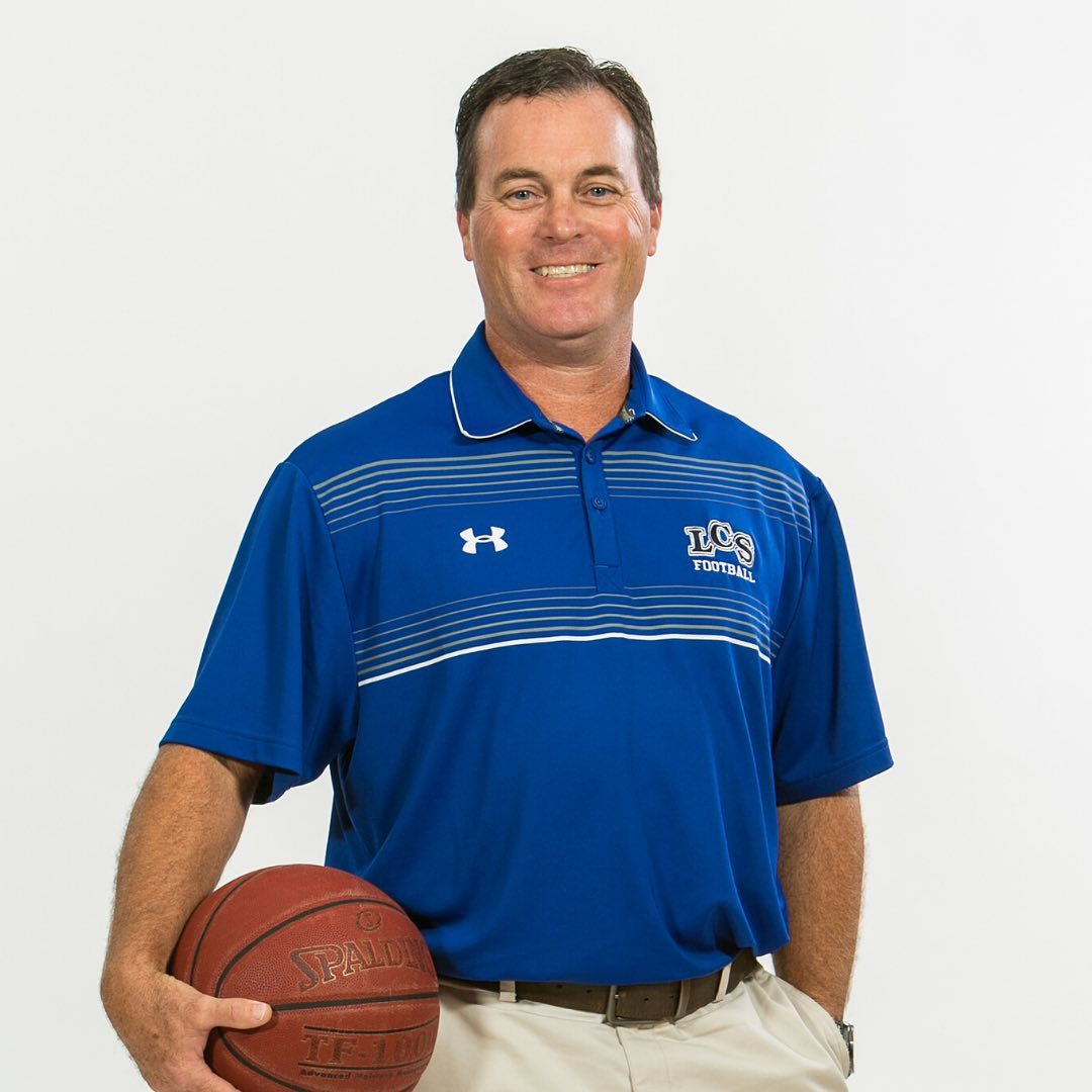 photo of Todd Radford holding a basket ball with an Lakeland Christian School blue shirt