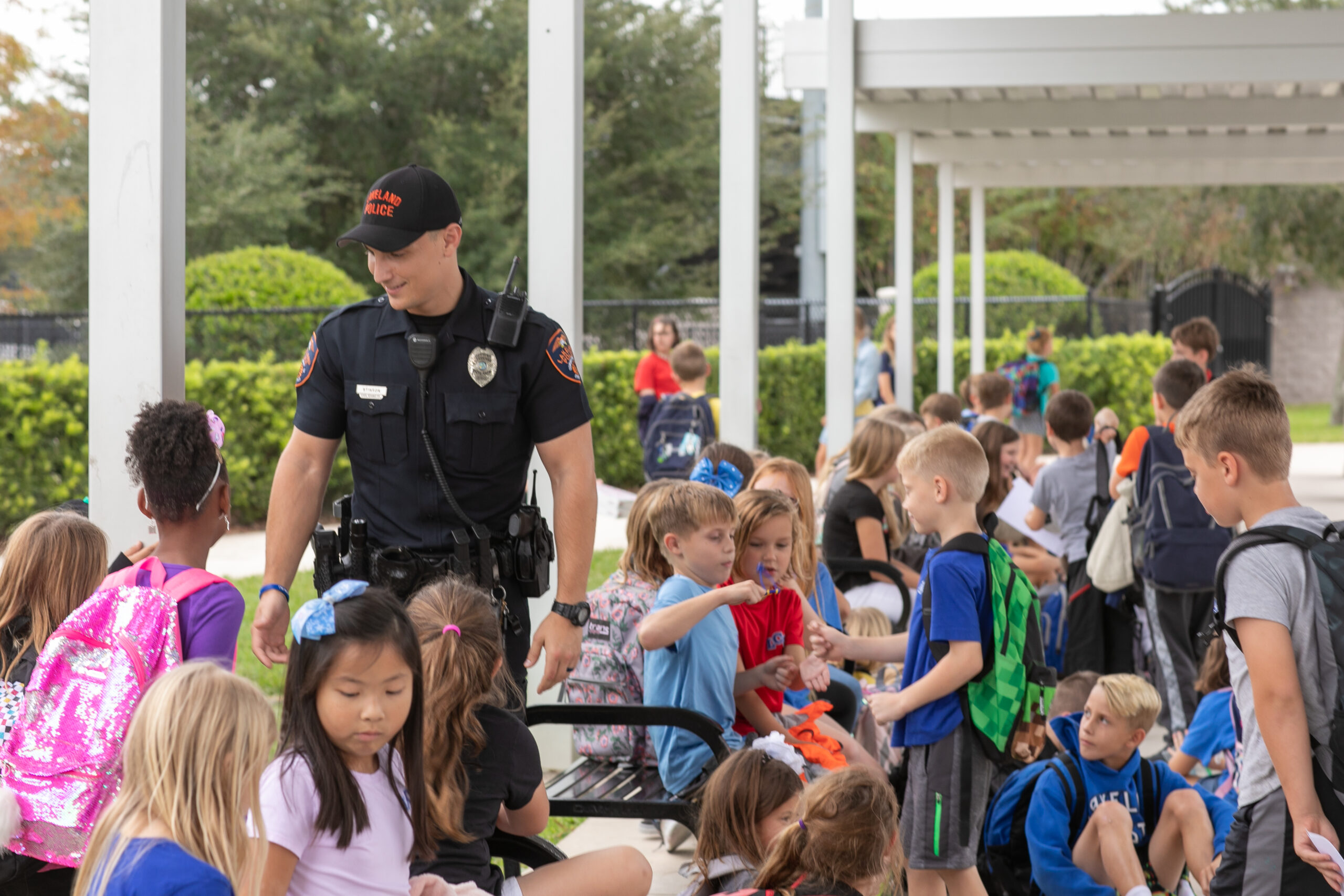 Officer shane stenson in uniform at the front of Lakeland Christian School helping the surrounding multitude of elementary students get to their parents after school. 