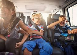 kids sitting in the backseat of a car laughing and playing