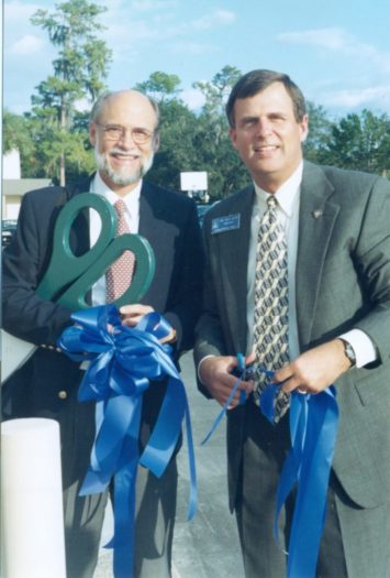 John Douglass and Michael Sligh (the head of the school) cut a blue ribbon for opening Lakeland Christian school